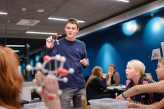 Gymnasieelev forklarer passioneret en gruppe børn om molekylestrukturer