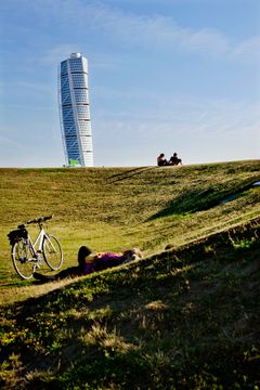 Cykel på græs med Turning Torso i baggrunden i Malmö.