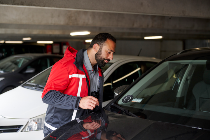Q-Park P-vagt tjekker p-skive og tilladelse i forruden på en sort bil