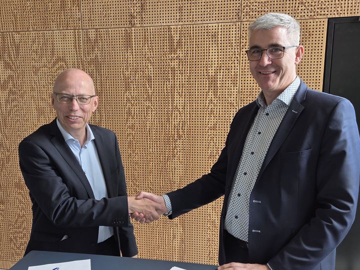 AAU's prorektor for forskning Jesper Wengel og DBI's forskningsdirektør Carsten Damgaard giver hånd ved underskrivelsen af den strategiske samarbejdsaftale.
