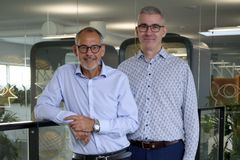 To personer står sammen på et kontor.