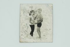 Familieminder i saltvand. Quyen Quyens mor tog familiens fotoalbums med sig under flugtenfra Vietnam. Her er det Quyens forælde og familiens amerikanske ven og soldat, gudfar til Quyen Billederne fik skader fra saltvand under flugten. Fra udstillingen "SOS - Reddet på åbent hav" på M/S Museet for Søfart.