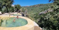 Tre pools der er bygget ind i bjergvæggen på Tid til ro's retrætested Enagron på Kreta.I baggrunden ses bjergene og en klar blå himmel.