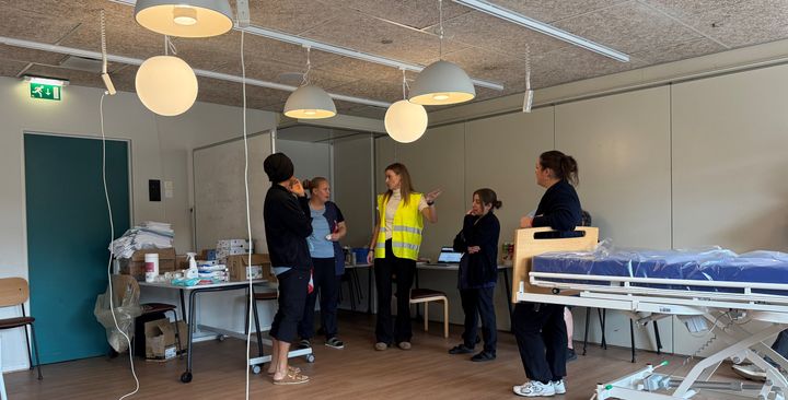 Medarbejdere og ledere planlægger modtagelsen af evakuerede borgere. De står ved en tavle.