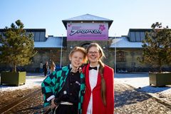 To unge står i cosplay foran Øksnehallen, hvor der hænger et stort skilt med J-Popcons logo.