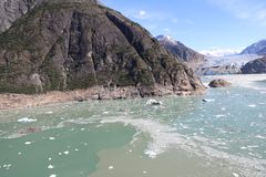 Skråt luftfoto af kystlinje med spor efter tsunamien i Tracy Arm-fjorden, set under rekognoscering. South Sawyer-gletsjeren ses i baggrunden.