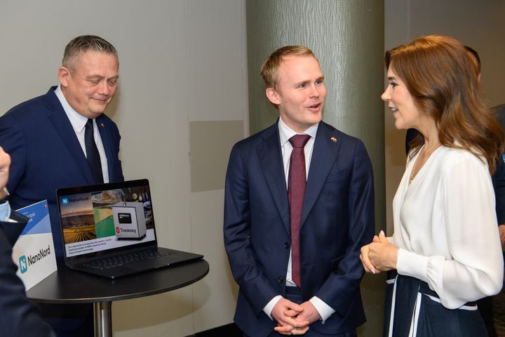 H.M. Dronning Mary spørger nysgerrigt ind til Tveskaeg-teknologiens anvendelser inden for lithium i Australien. (På billedet, til venstre: Jens Holst Nielsen, Dansk Industri; i midten: Martin Mindorf, CCO NanoNord A/S; til højre: H.M. Dronningen). Foto: Udenrigsministeriet.