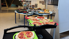 Børnene var med til at lave maden og pyntede sine egne pizzaer. Maden blev serveret til forældremøde, så både børn og forældre spiste med.