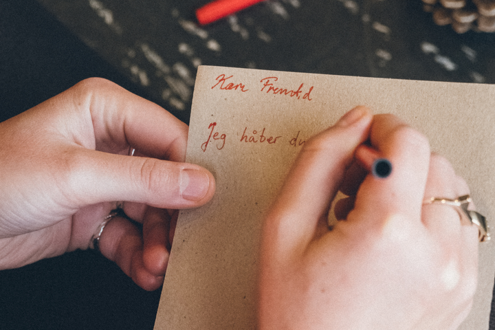 En person skriver et brev på brunt papir. På brevet står "Kære fremtid, jeg håber du". I projektet ‘Håb i Demokratiet’ skriver unge Kærlighedsbreve til Fremtiden om alt det, de håber på, drømmer om og frygter for fremtiden.