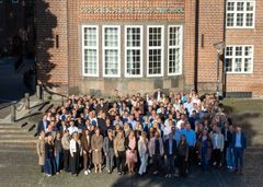 Her ses en stor gruppe medarbejdere fra Sparekassen Danmarks afdelinger i Aalborg og Nørresundby foran sparekassens afdeling på Budolfi Plads.