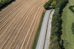 Supercykelstien Jyllinge-Stenløseruten set fra oven med marker, vej og træer