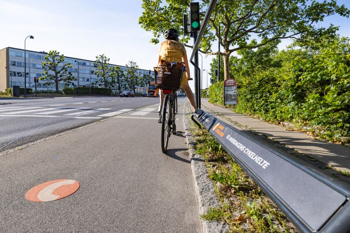 En cyklist venter på grønt lys ved en supercykelsti