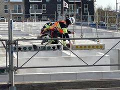 Arbejder installerer betonelementer i nye rækkehuse i Gellerupparken.