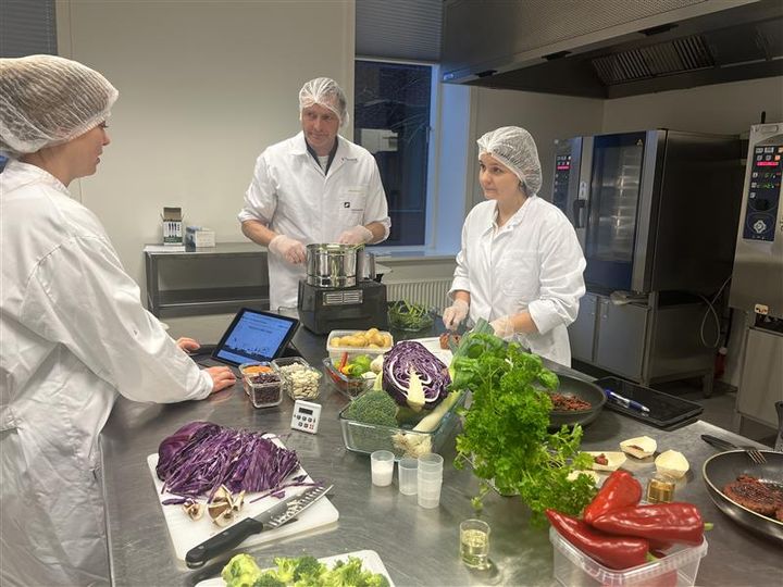 Tre personer i laboratoriekøkken