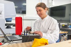 Kvindelig forsker arbejder i laboratorium med teknisk udstyr og tekstilprøver.