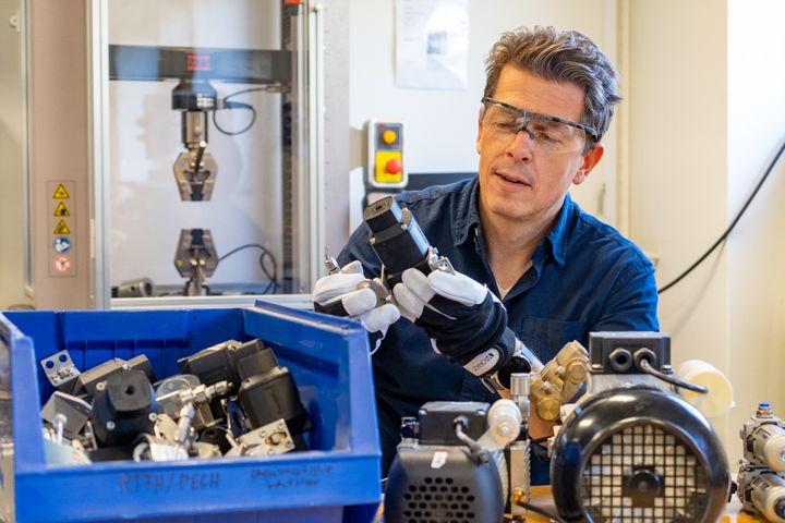 En mand i laboratorie arbejder med elektriske komponenter.