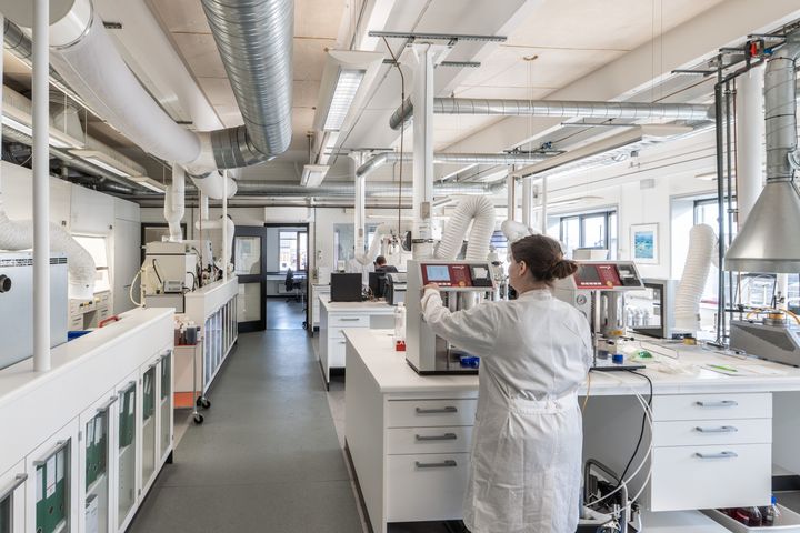 En forsker arbejder i et moderne laboratorium med forskellige tekniske apparater.