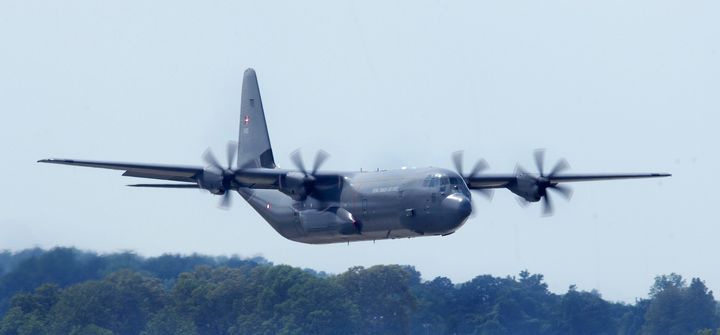 Et militærfly i luften mod en blå himmel.