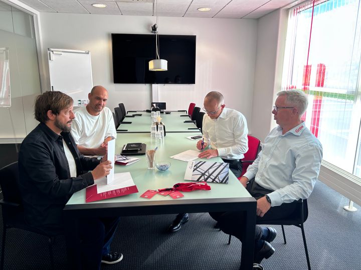 Repræsentanter fra DIF og GROW skriver her den nye samarbejdsaftale under. Til venstre ses projektchef Rune Oland Tangaard (forrest) og udviklingskonsulent Mikkel Rask – begge fra DIF. Til højre ses ejer af Give Steel og stifter af GROW, Torben Larsen (bagerst), og projektchef Benny Christensen (også fra GROW).