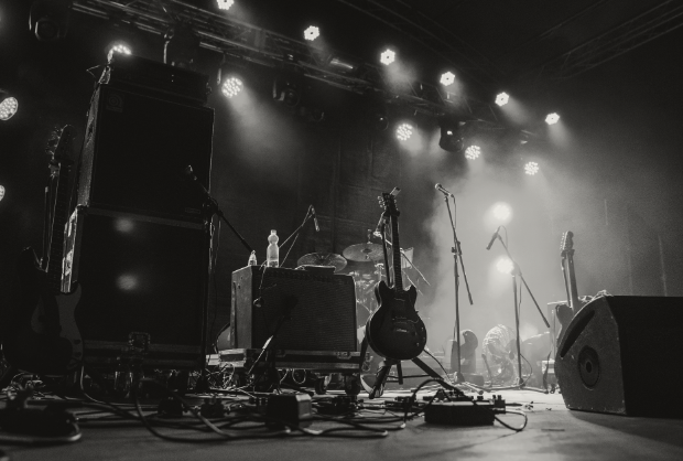 Tom scene med guitar, trommer og højttalere klar til koncert