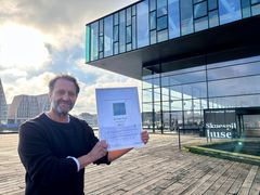 Kim Fridbjørg, chef for grøn omstilling på Det Kongelige Teater, med Green Key-certificeringen for Skuespilhuset