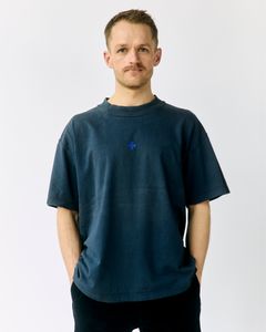 Daniel, der er socialpædagog på et af Blå Kors' tilbud, i en t-shirt fra kollektionen 'Acts of Kindness'. Foto: Rasmus Arentsen