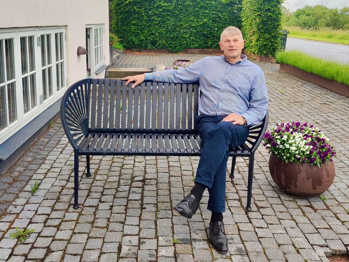 Christian Wolff-Petersen, ejer af GH Form, siddende på citybænken skabt i samarbejde med Nanna Ditzel i 1997.