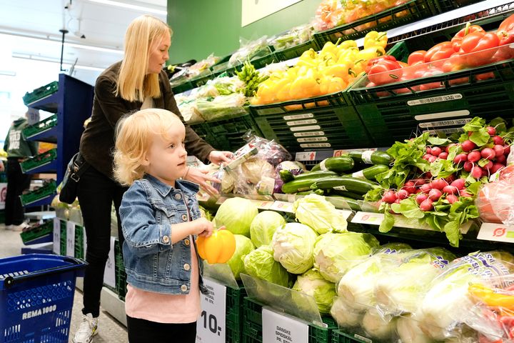 Mor og barn køber frugt og grønt i en købmandsbutik