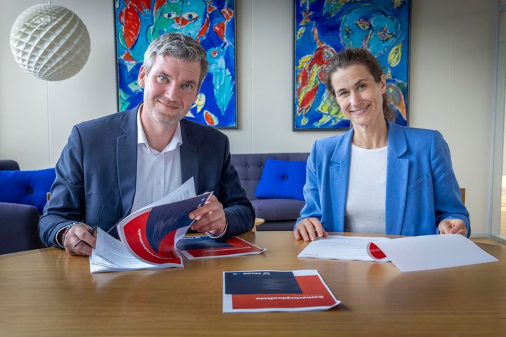 Mads Samsing, forbundsformand i HK Danmark, og Johanna Rastad, direktør for Falck i Skandinavien, sidder ved et bord og underskriver partnerskabsaftalen, der fra den 16. juni giver alle HK's medlemmer mulighed for adgang til en online læge og til en sundhedsordning.