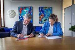 Mads Samsing, forbundsformand i HK Danmark, og Johanna Rastad, direktør for Falck i Skandinavien, sidder ved et bord, hvor de sætter deres signaturer på partnerskabsaftalen, der fra den 16. juni giver alle HK's medlemmer mulighed for adgang til en online læge og til en sundhedsordning.
