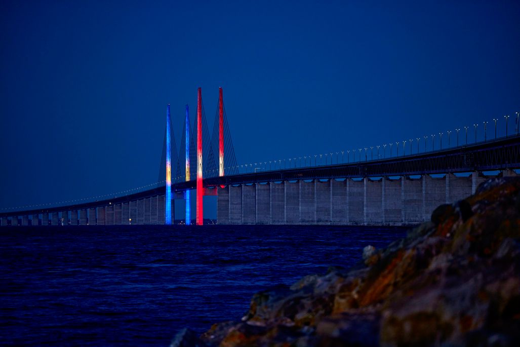 Billede af Øresundsbronn oplyst om natten med farvet lys.