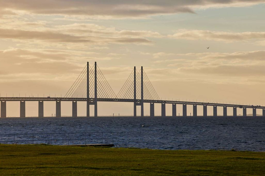 Billede af Øresundsbron i solnedgangen over havet.