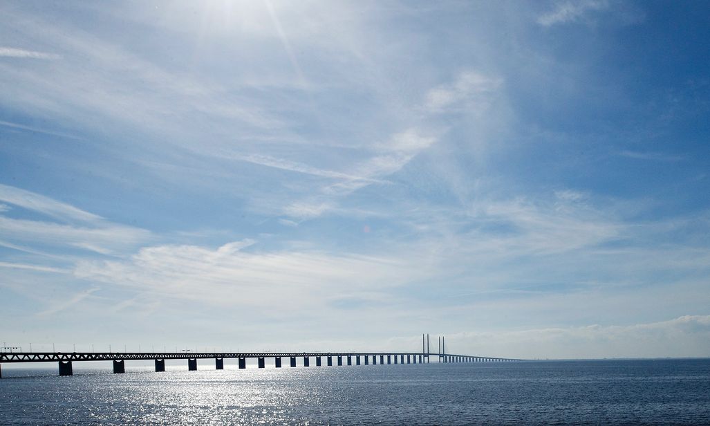 Billede af Øresundsbroen under en blå himmel med sollys.