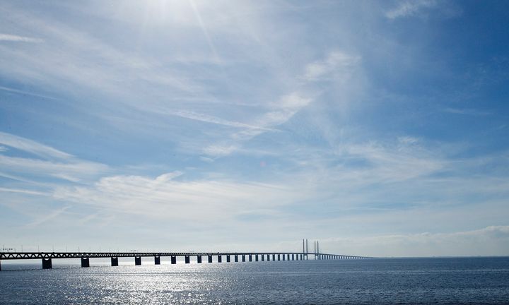 Billede af Øresundsbroen under en blå himmel med sollys.