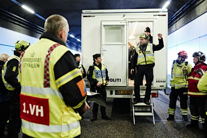 Beredskabsøvelse i gang med redningspersonale og politi ved en stor hvid lastbil.