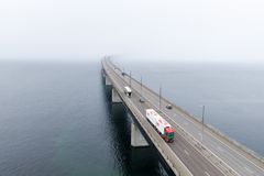 Luftfoto af en lastbil med modulvogntog, der kører over Øresundsbron i let tåge.