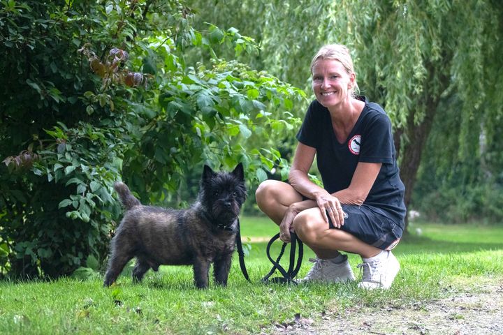 Internatsleder Bonnie Brill sammen med en sort terrier på grunden ved Dyreværnets internat i Kolding