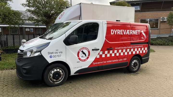 Billede af Dyreværnets dyreambulancer med nyt look. Forenden er hvid med logo, mens bagenden er rød med teksterne: Dyreværnet har reddet kæledyr siden 1898 og Anmeld misrøgt af kæledyr på dyreværnet.dk