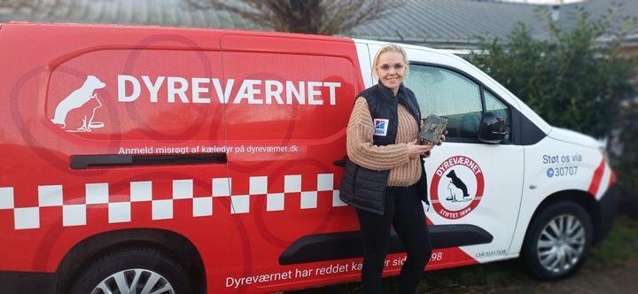 Udrykningschef Nina Amdi står foran Dyreværnets rød-hvide dyreambulance med vildtkamera i hånd
