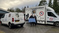 To biler fra Kattens Værn og Dyreværnet parkeret foran et hus med personale ved siden af.