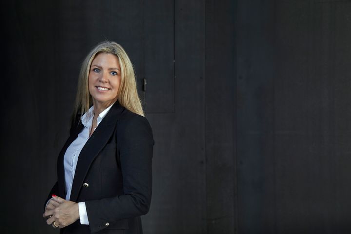 Tina%20Hedegaard%2C%20k%E6dedirekt%F8r%20i%20Nybolig%2C%20if%F8rt%20en%20m%F8rk%20blazer%20og%20hvid%20skjorte%2C%20foran%20en%20m%F8rk%20baggrund.
